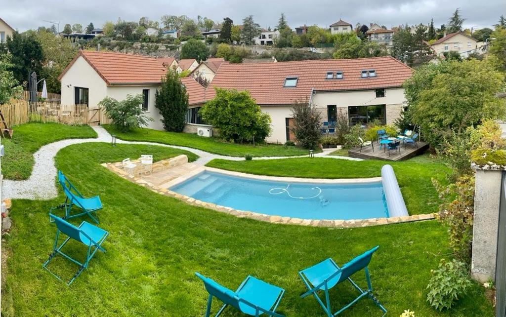 第戎Proche centre ville, gîte 4 étoiles avec piscine的后院设有游泳池、椅子和房屋