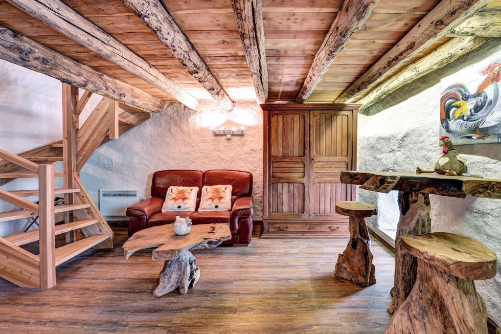 布里昂松LA FERME de BELLINE Chalets ou Gîtes & SPA的带沙发和木制天花板的客厅