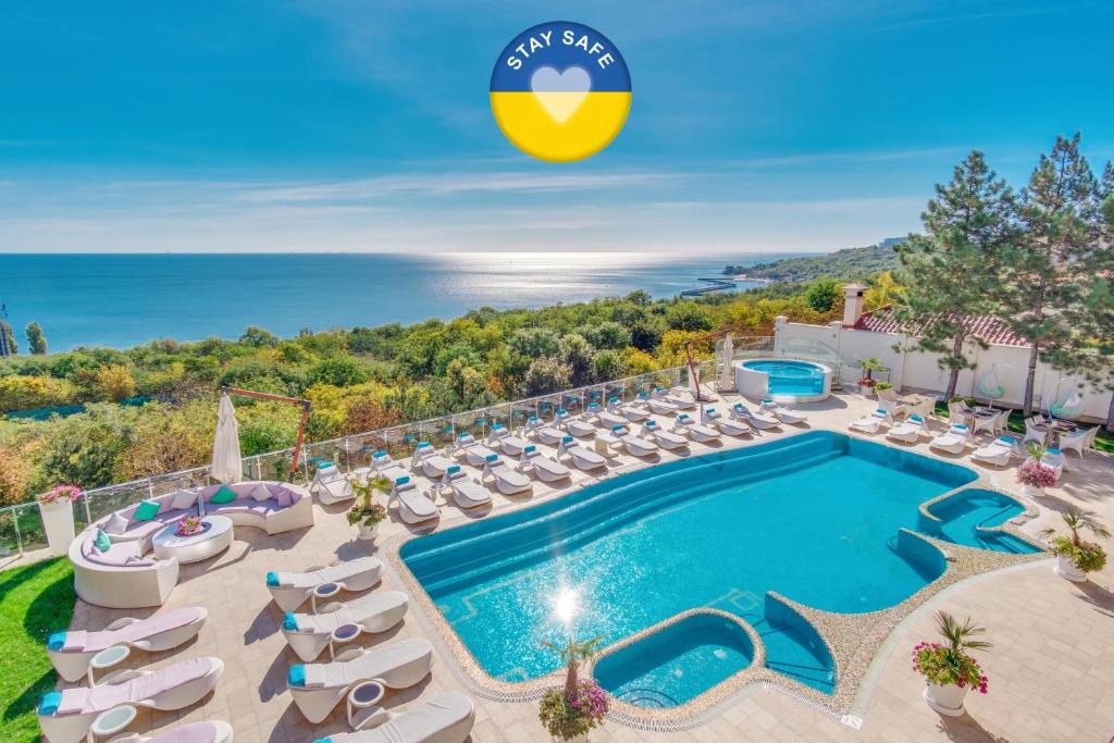 敖德萨Hotel Panorama De Luxe的别墅的游泳池景象,配有躺椅
