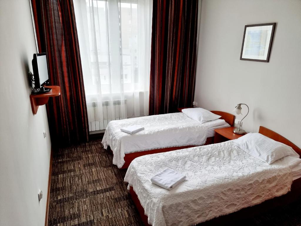 华沙Noclegi Stadion Bed & Breakfast的酒店客房设有两张床和窗户。
