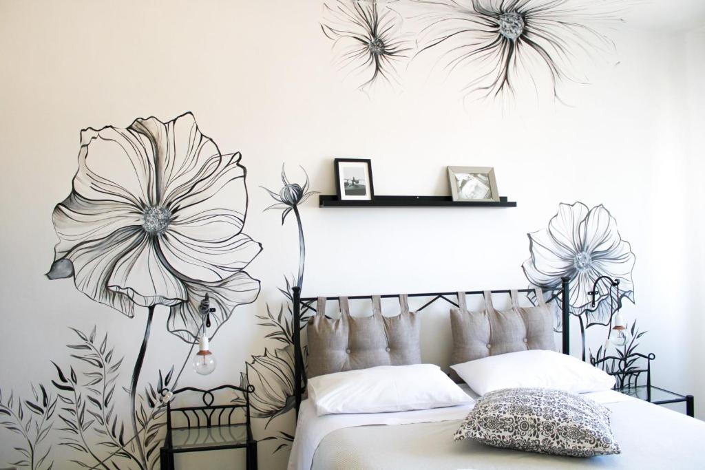 罗马优福诺维荫友好公寓的卧室配有一张墙上鲜花的床