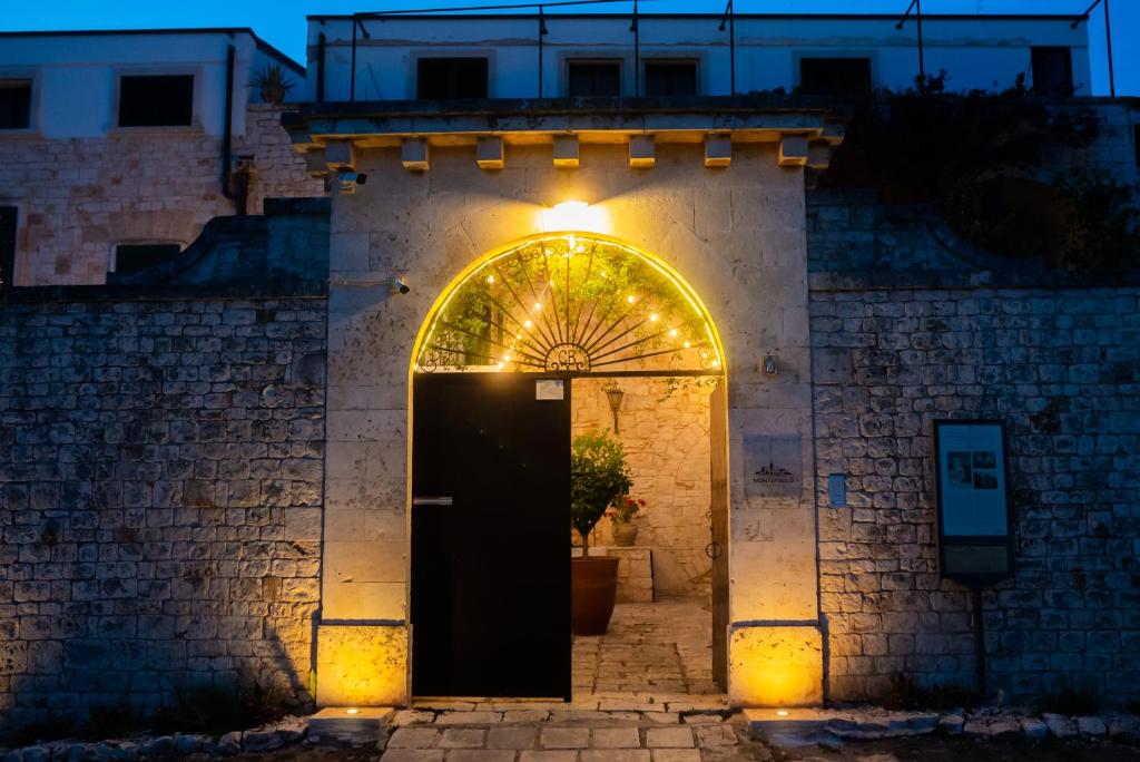孔韦尔萨诺Masseria Montepaolo Dimora di Charme的建筑的入口,有门和灯