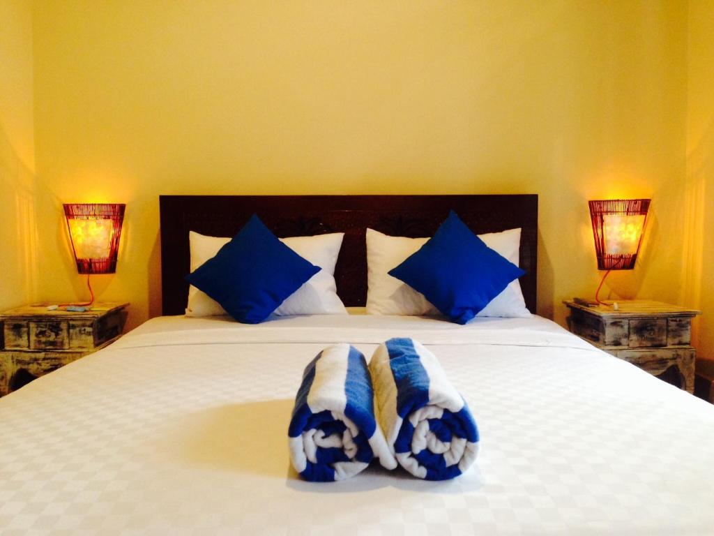 库塔赤林库塔民宿的一间卧室配有一张带蓝色和白色枕头的床