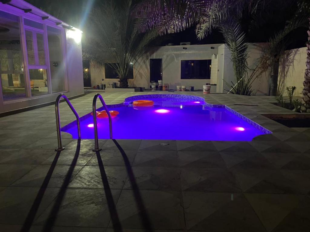 阿尔哈姆拉Dar Alhamra INN نزل دار الحمراء的夜晚在院子里的泳池里,有紫色的灯光