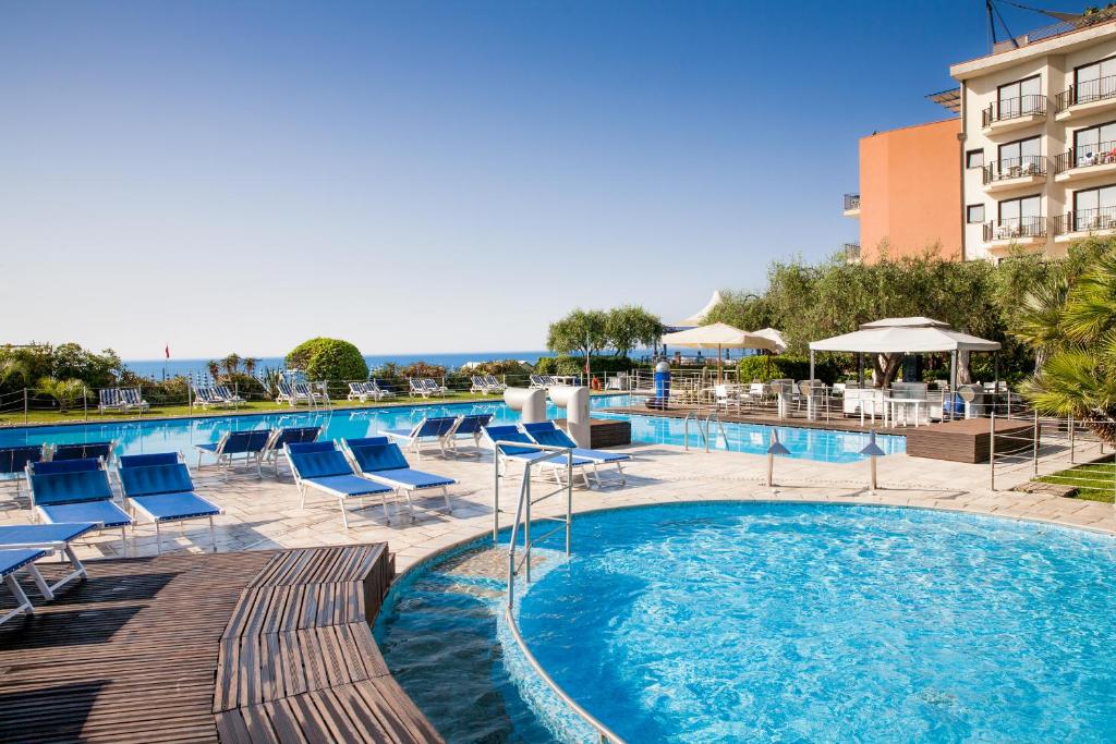 迪亚诺马里纳戴安娜大酒店的一个带椅子的游泳池和一间酒店
