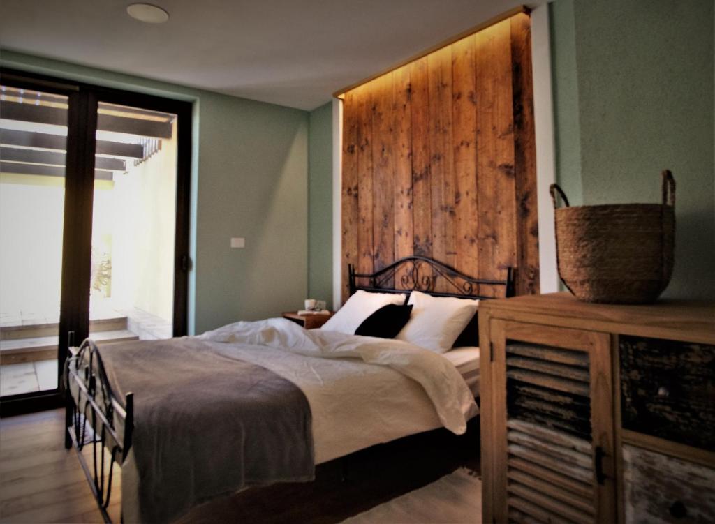 多博沃Olivea的一间卧室设有一张床和木墙