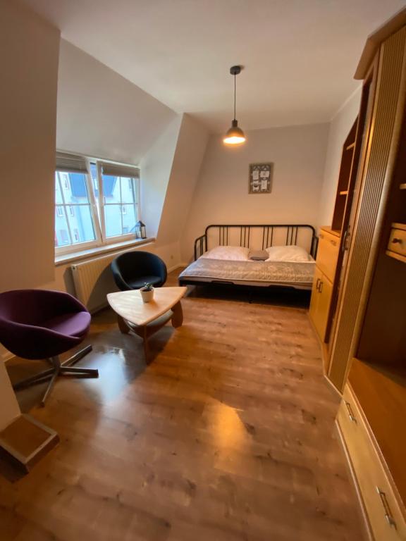 利希滕斯泰因Bezauberndes Stadtidyll的一间卧室配有一张床、两把椅子和一张桌子