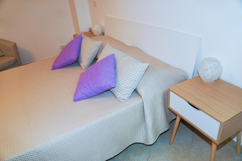 索伦托IL GLICINE的一间卧室配有一张带紫色枕头的床