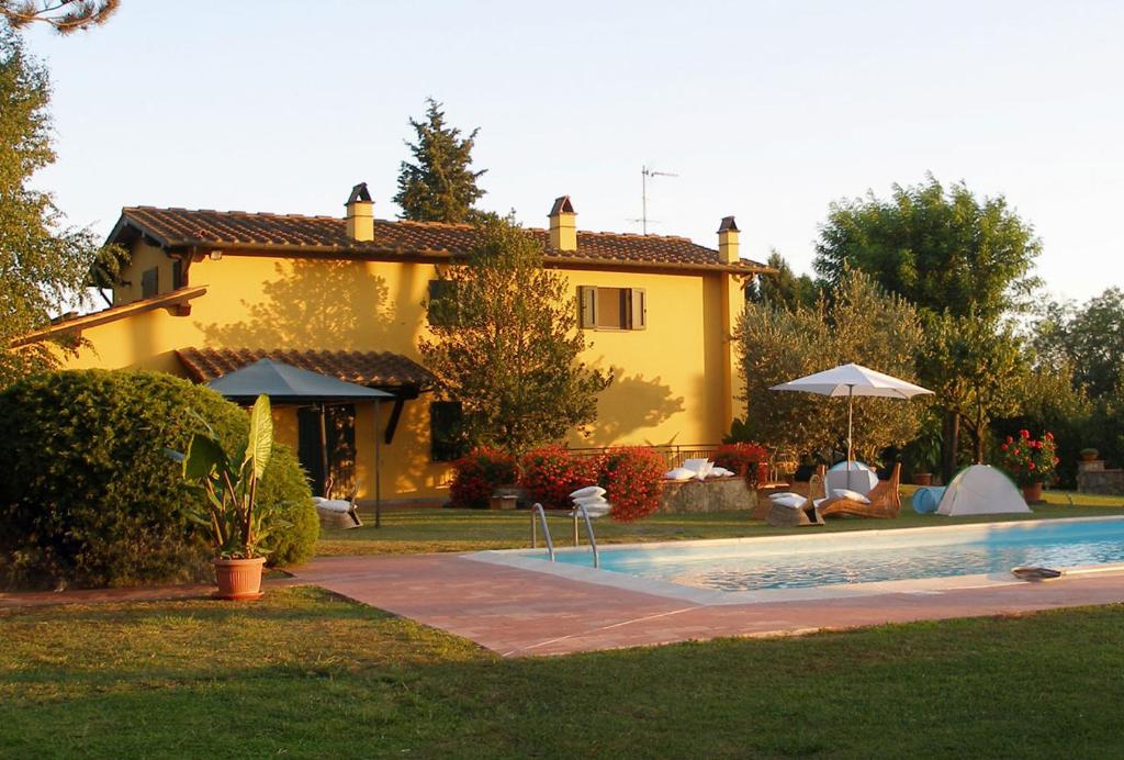富切基奥La Casa di Agata Deluxe的黄色的房子,前面有一个游泳池
