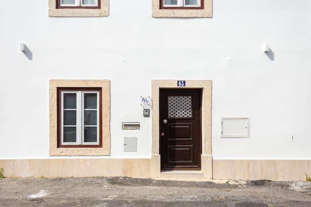 里斯本A Treat in Belém的白色的建筑,设有棕色的门和两扇窗户