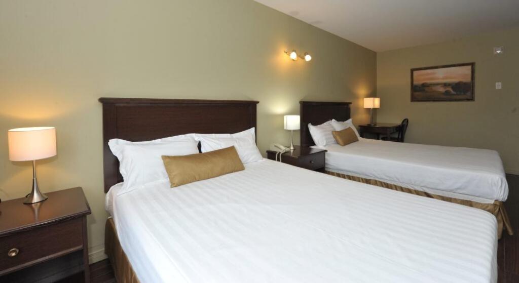 魁北克市旅游酒店的酒店客房设有两张床和两盏灯。