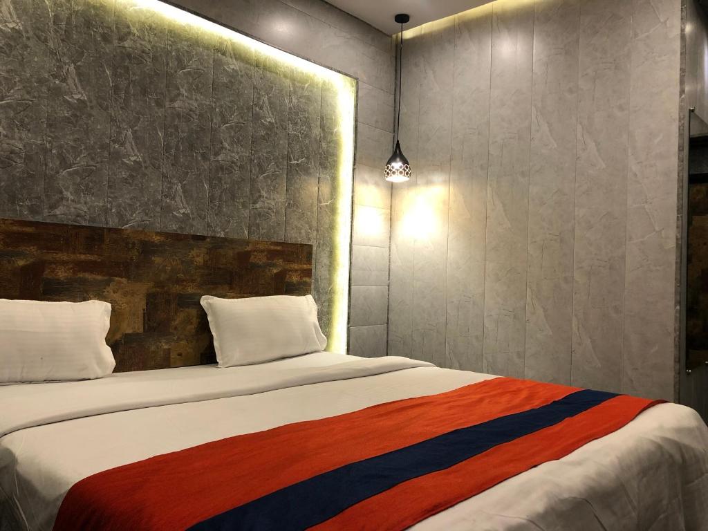 巴加Aariv Inn的一间卧室配有一张带彩色毯子的床