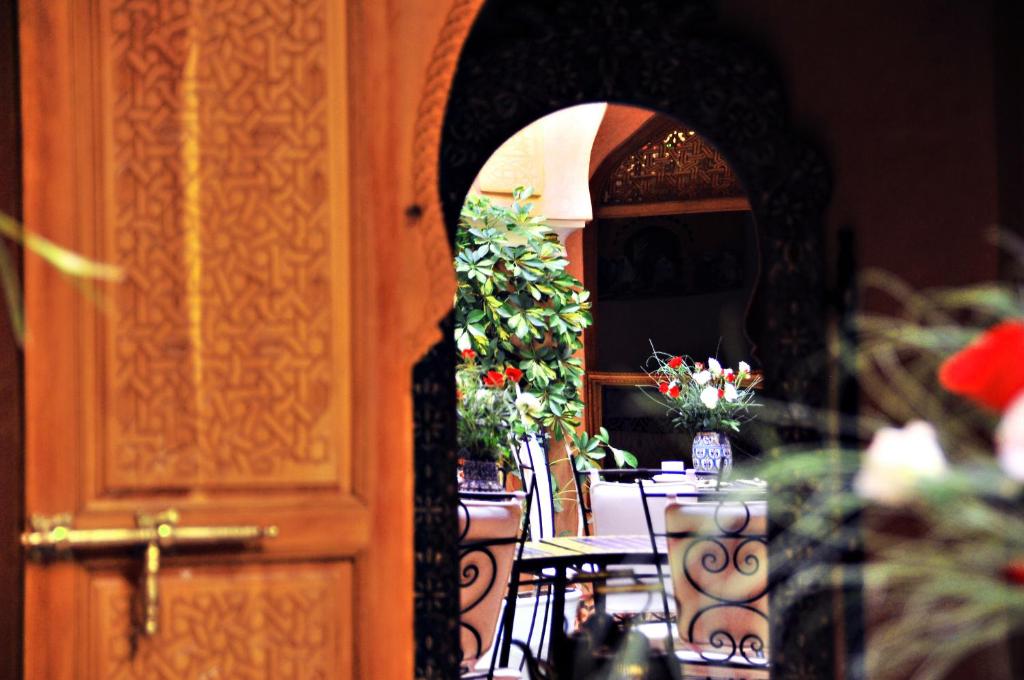 马拉喀什本萨义德摩洛哥传统住宅的一间设有鲜花桌和门的房间