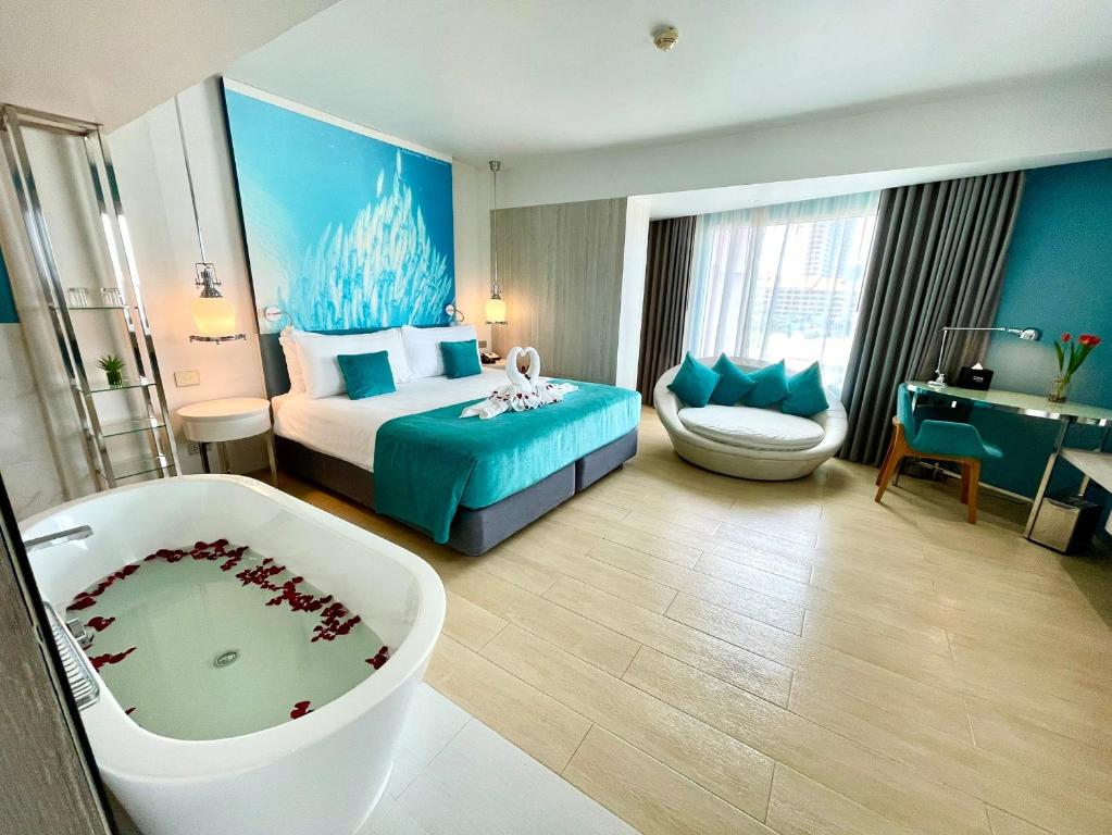 南芭堤雅Kudos Parc Pattaya的酒店客房配有一张床和浴缸。
