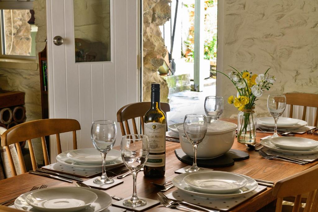 多尔盖罗Finest Retreats - Hope House - Ty Gobaith的一张桌子,上面放着一瓶葡萄酒和眼镜