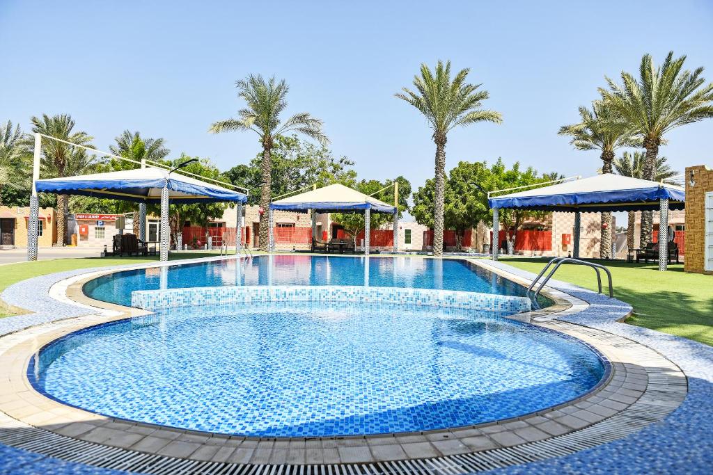拜尔卡OYO 138 Gulf Sand Motel的度假村的游泳池,配有蓝色遮阳伞