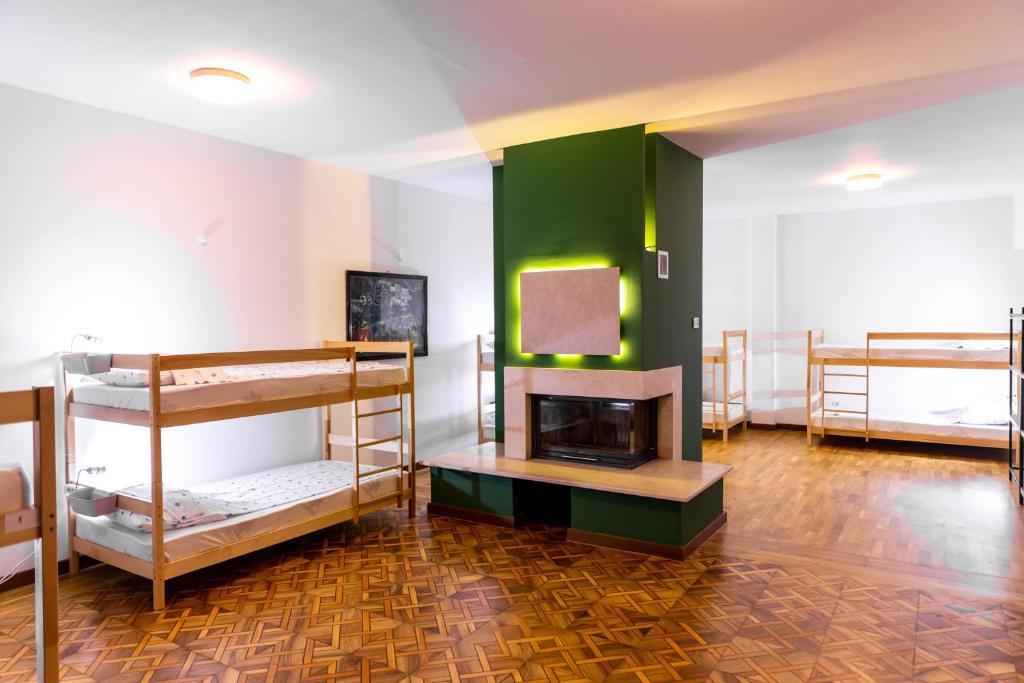 普里什蒂纳Alias Hostel的客房设有三张双层床和壁炉。