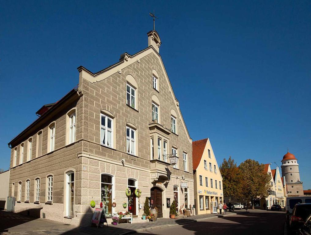 诺德林根Weinstube Sinas Brettl的一座大型砖砌建筑,上面有十字架