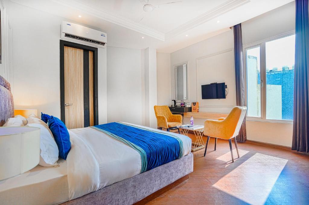 阿姆利则Hotel Grand Cabbana By Levelup Hotels的酒店客房带一张床、一张桌子和椅子