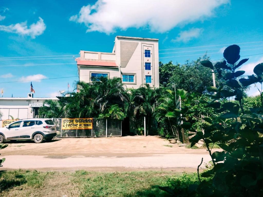 DongargarhIndian Family Lodge, Rajnandgaon, Chhattisgarh的停在大楼前的白色汽车