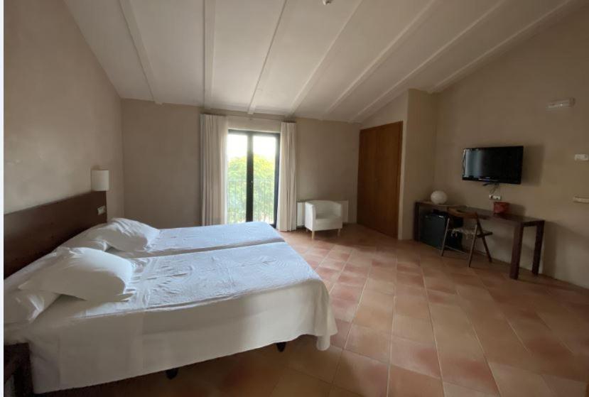 莫拉塔利亚Hotel Rural Casa Pernías的卧室配有白色的床和电视。