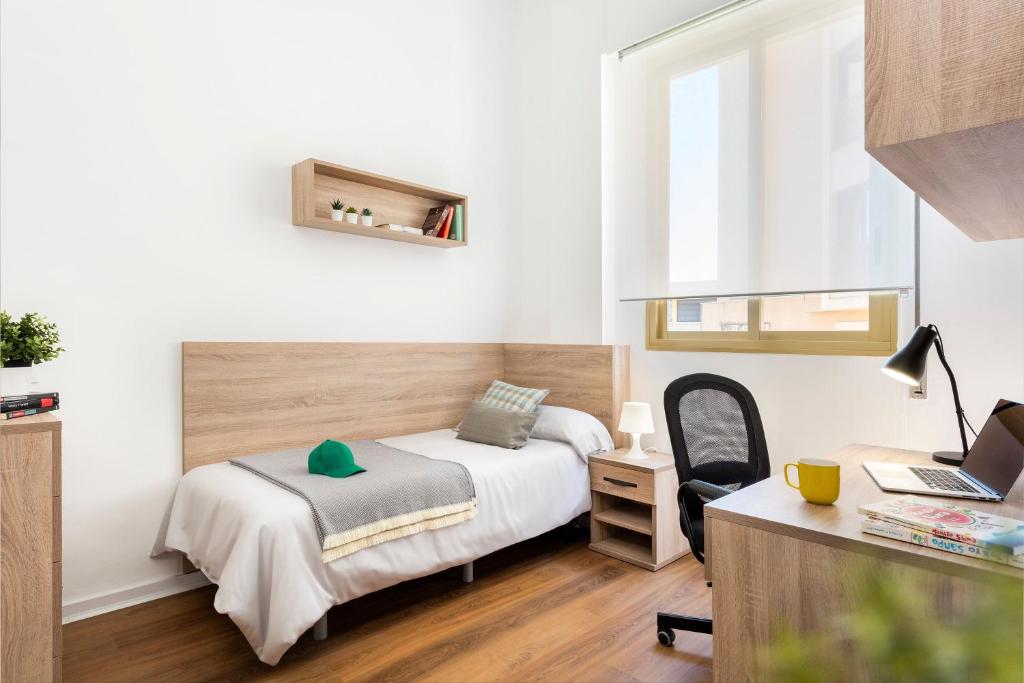 塞维利亚Micampus Armendariz Student Residence的一间卧室配有一张床、一张桌子和一把椅子