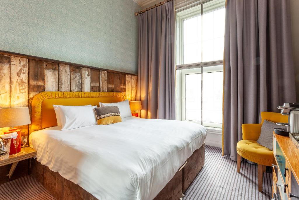 都柏林House Bedrooms Dublin的酒店客房带一张大床和一把椅子