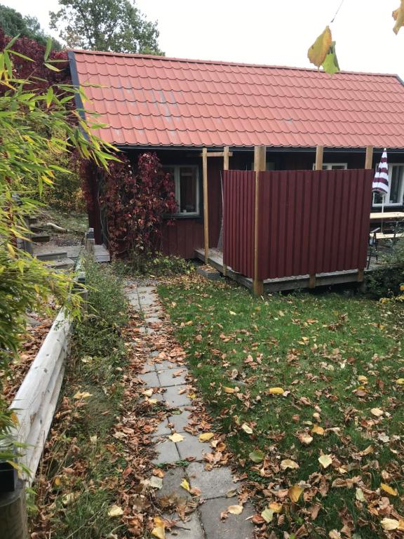埃斯基尔斯蒂纳Trevlig stuga på landet, centralt 8km från Centrum的一座红色屋顶的房子和一个院子