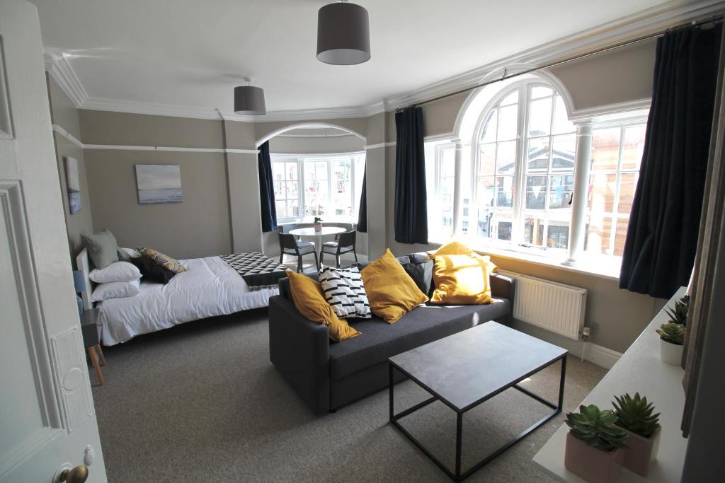 考斯Pier View Studio Apartment的客厅配有沙发和1张床