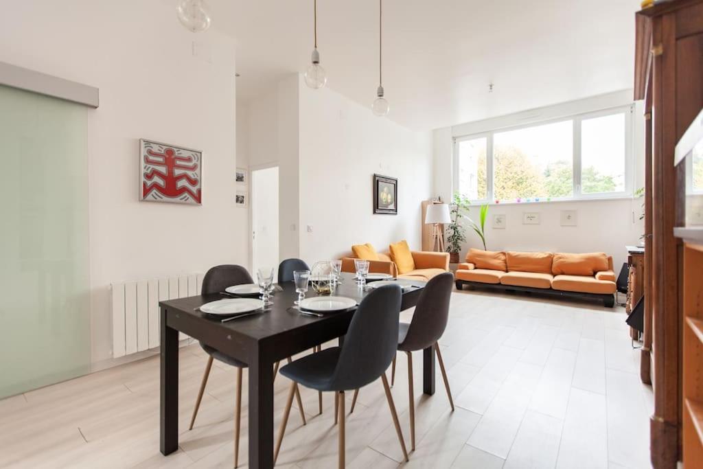 斯特拉斯堡R-appartements Strasbourg cosy Orangerie pour vos séjours en famille ou entre amis的一间用餐室,配有黑色的桌子和椅子