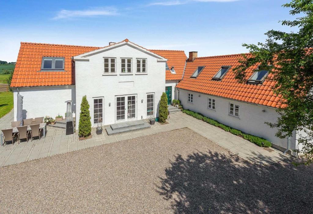 SvebølleFarmens Gæstehus的一座白色的大房子,有橙色的屋顶