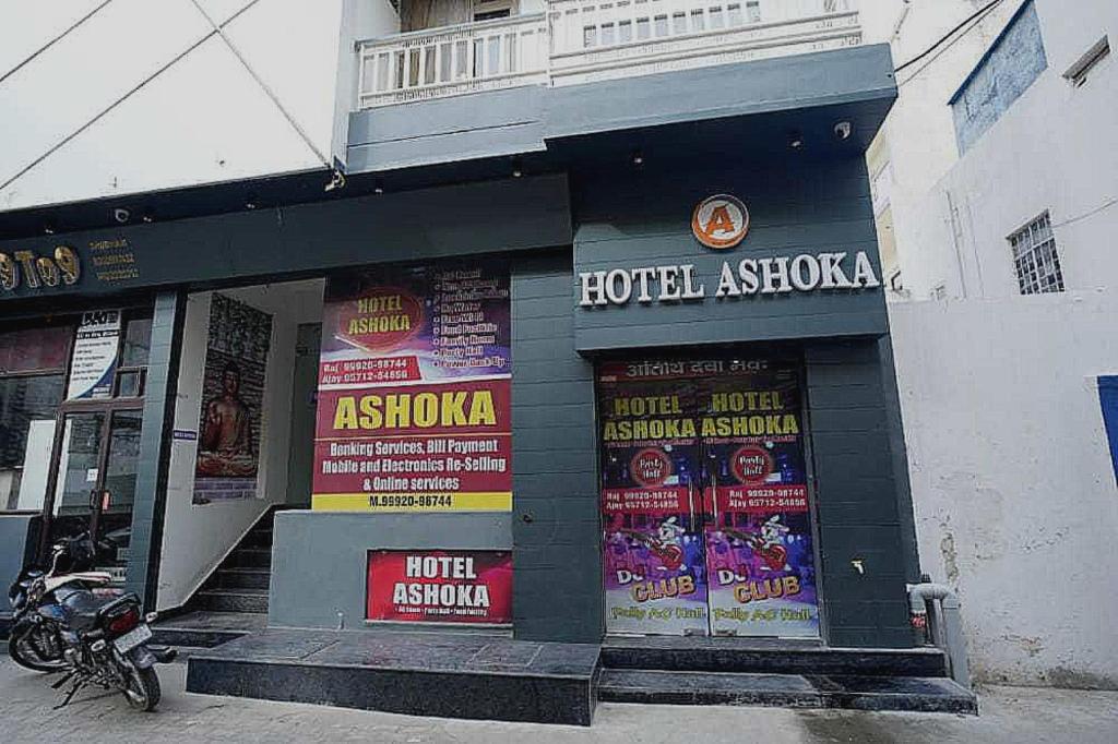 希萨尔Hotel Ashoka的一辆停在酒店前面的摩托车