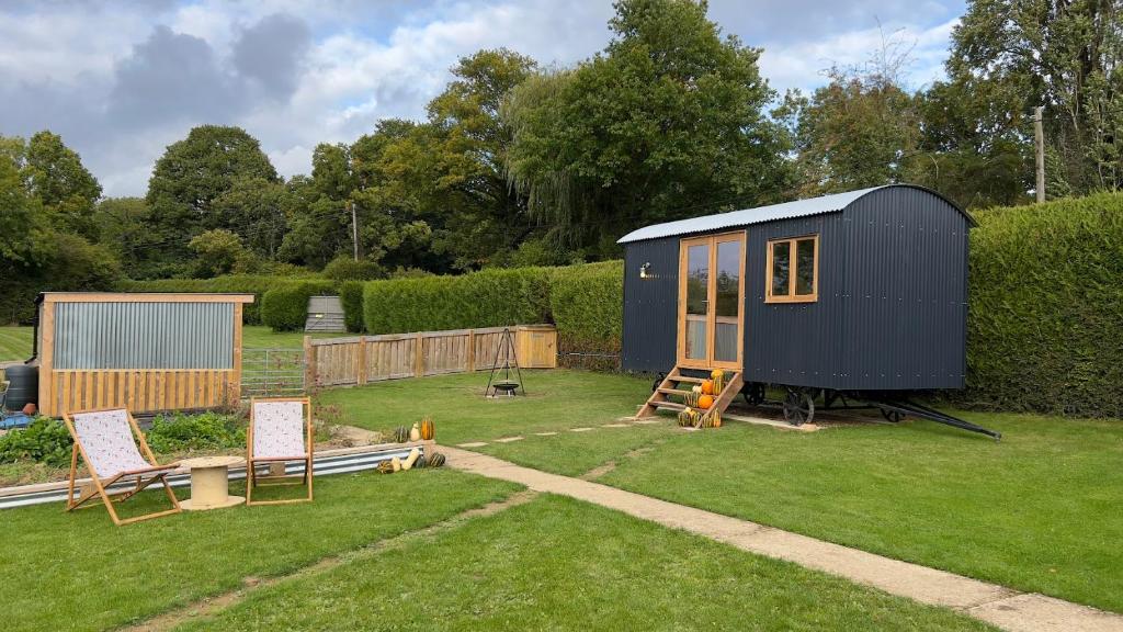 LamberhurstShepherds Hut at Cedar Gables的坐在院子顶上的蓝色小房子