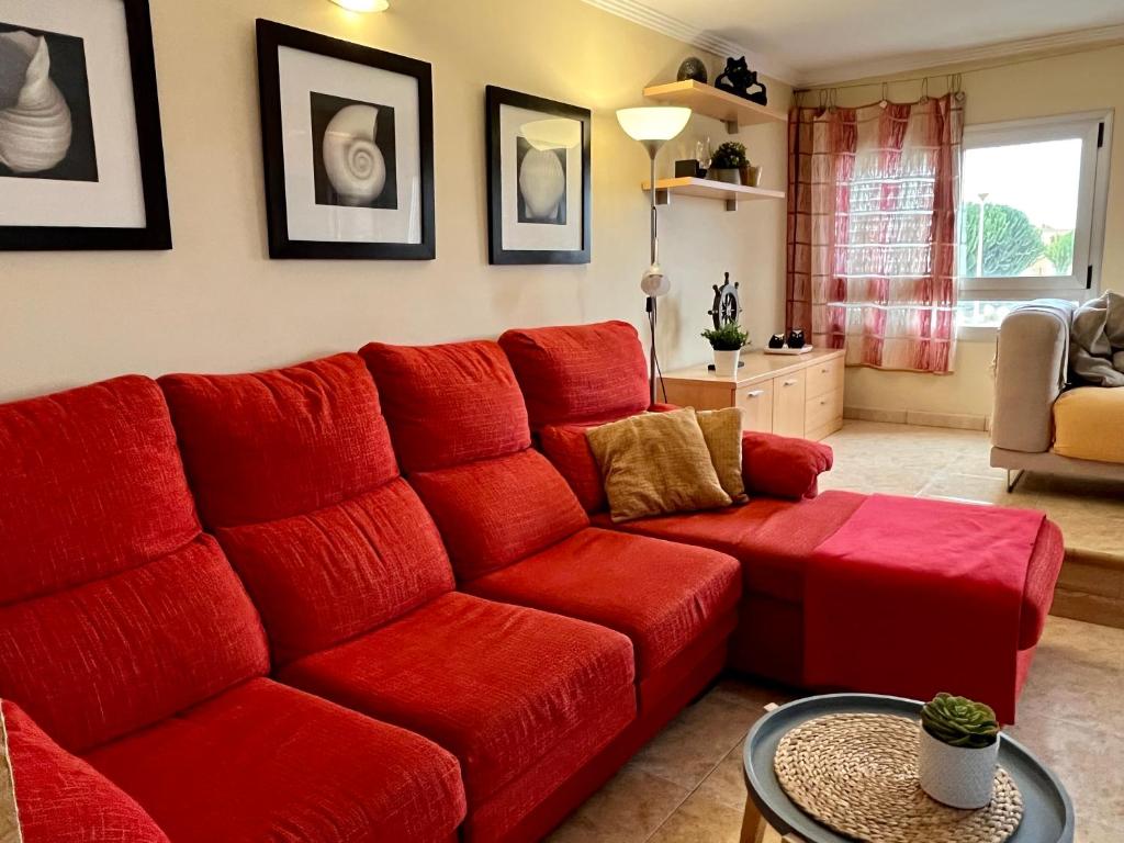 阿里纳加Las Nasas, Acogedor apartamento cerca de la playa的客厅里的红色沙发