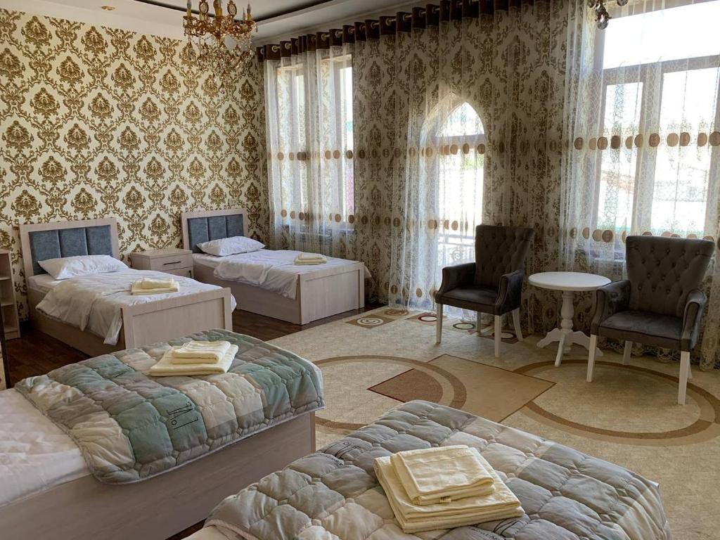 KogonTURKISTAN Hotel的一间卧室配有两张床和一张桌子及椅子