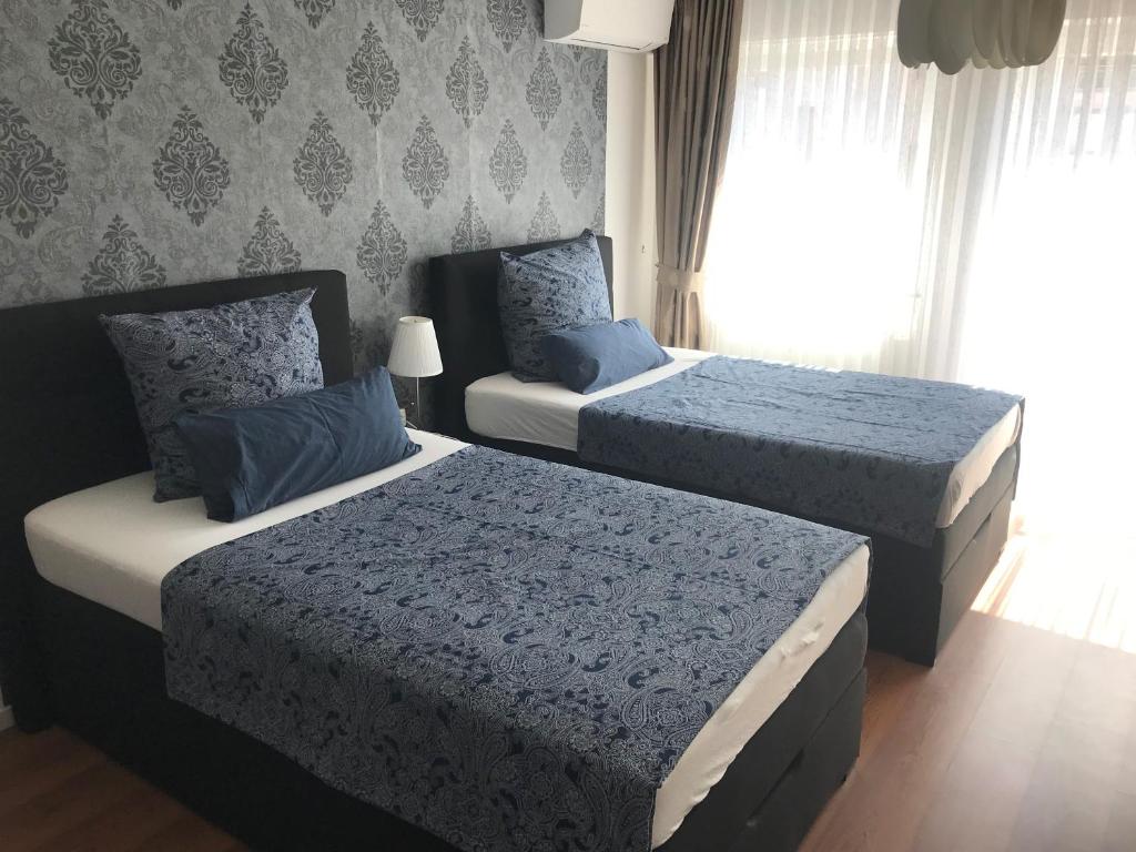 美因茨Maxim Apartments Mainz的一间卧室配有两张带蓝白色床单的床