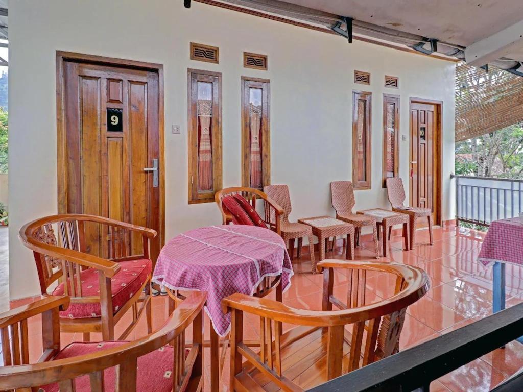 伦邦Adinda Homestay Lembang的房间里的一排桌子和椅子