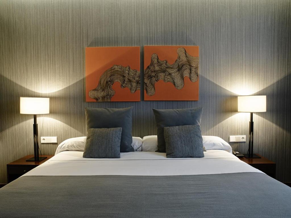 拉科鲁尼亚卡利斯玛丽内达酒店的一间卧室配有一张大床和两盏灯
