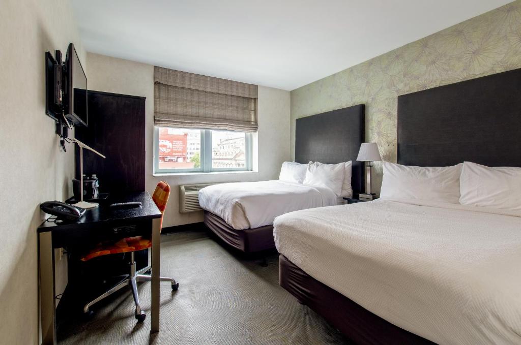 纽约Solita Soho Hotel的酒店客房配有两张床和一张书桌