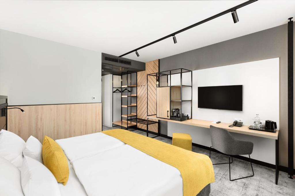 塞格德塞格德艺术酒店的一间卧室配有一张床、一张书桌和一台电视。