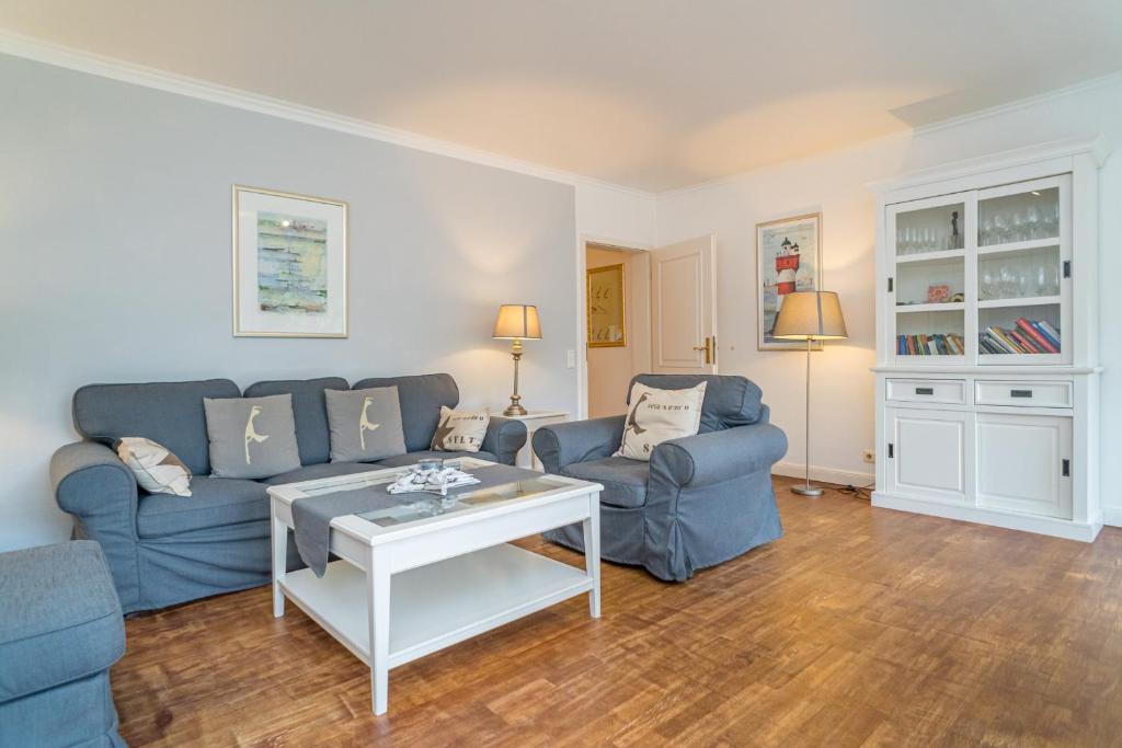 曼克玛肖Söns Hüs的客厅配有2张蓝色的沙发和1张桌子