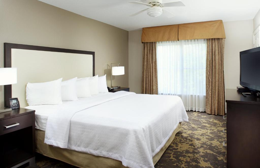 夏洛特Trellis Lake Pointe的一间酒店客房,配有一张大床和一台平面电视