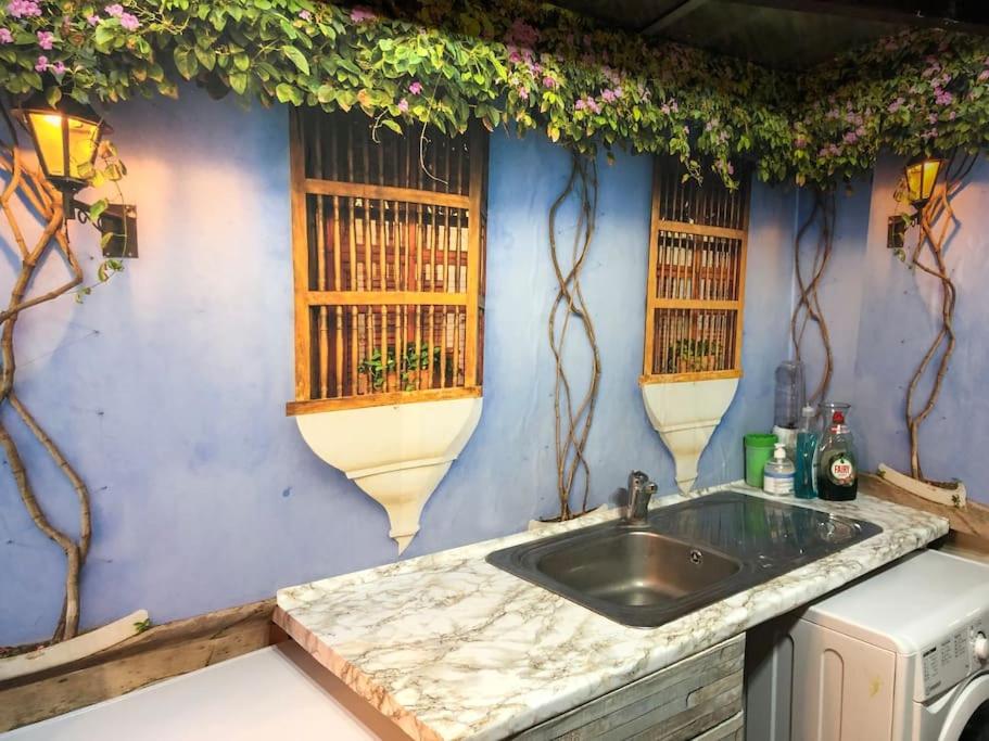 伦敦Cheerful 4 bedroom house with garden free parking的厨房设有水槽和蓝色的墙壁