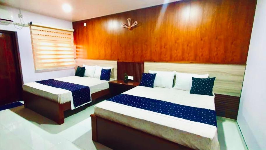 卡特勒格默Hotel SU kataragama的一间卧室配有两张带蓝白色床单的床