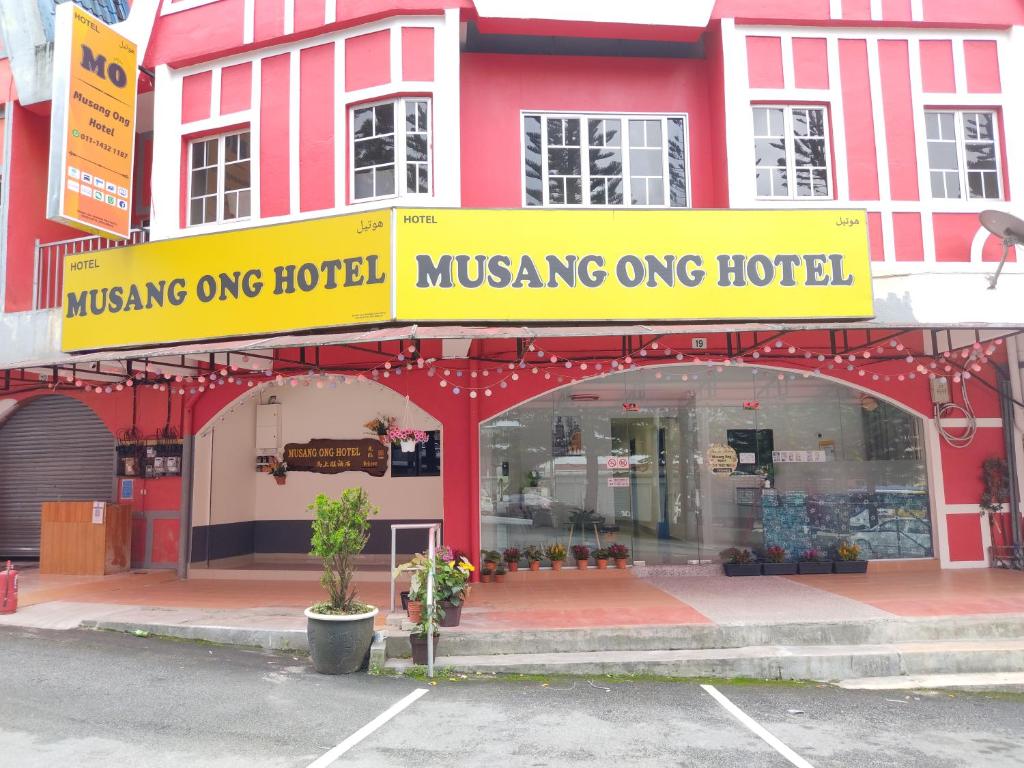 金马仑高原MUSANG ONG HOTEL的一座黄色的建筑,上面写着一个酒店护理的标志