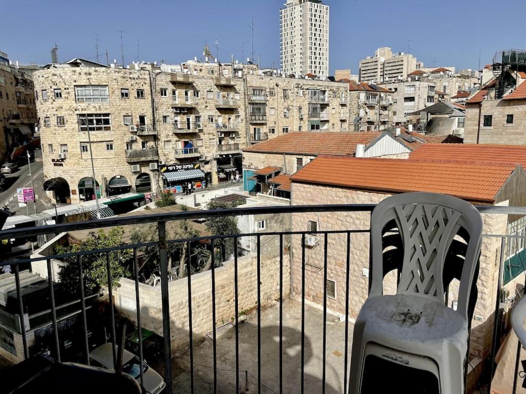 耶路撒冷Gorgeous duplex in heart of Jerusalem的椅子坐在俯瞰着城市的阳台