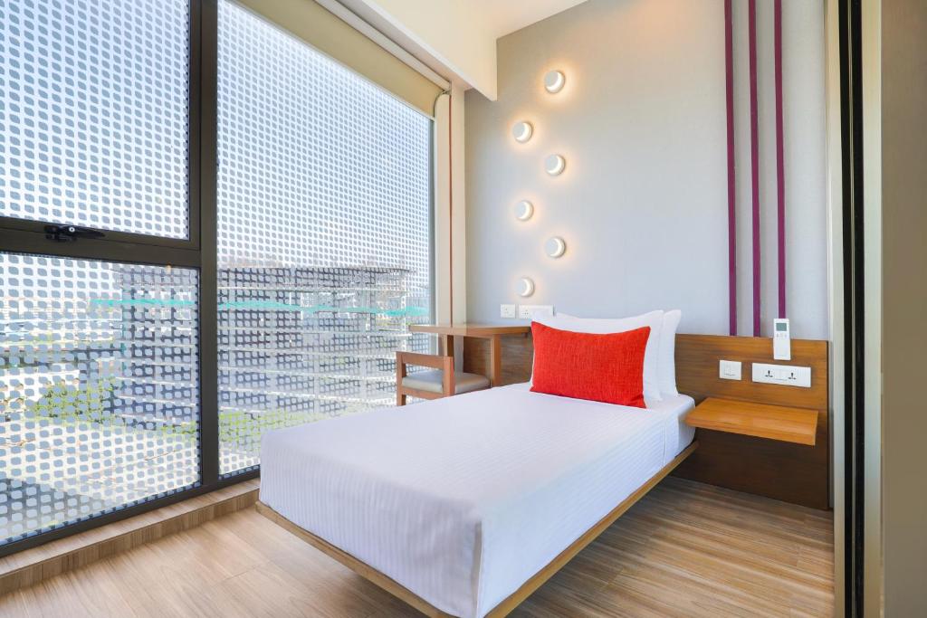孟买Lemon Tree Hotel, Kalina, Mumbai的一间卧室设有一张床和一个大窗户