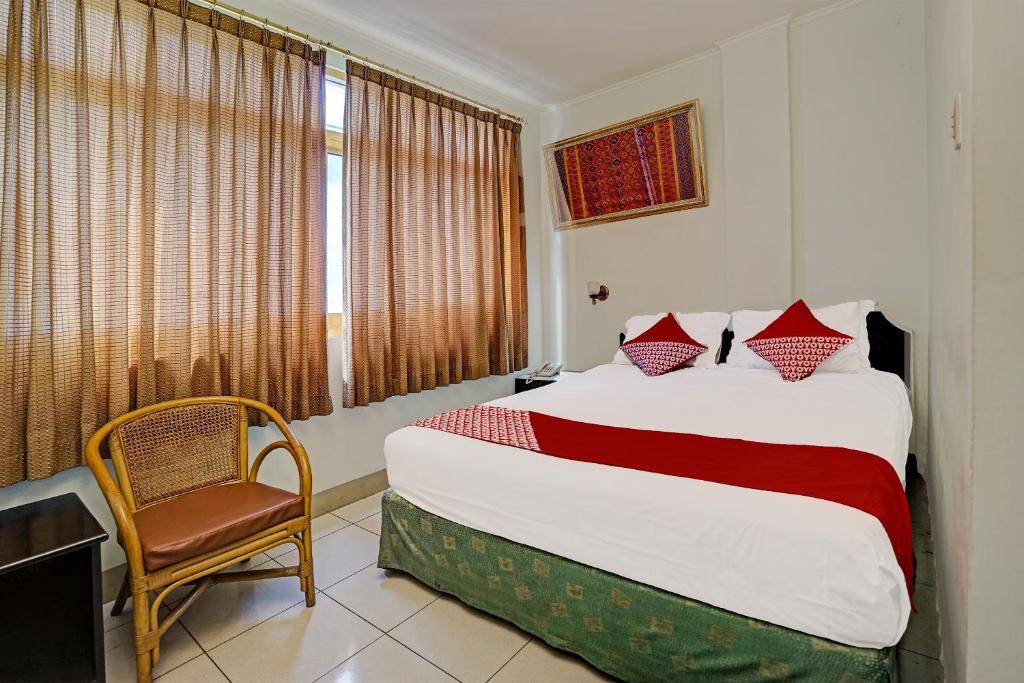 巨港SUPER OYO 91805 Hotel Wisma Bari的卧室配有床、椅子和窗户。