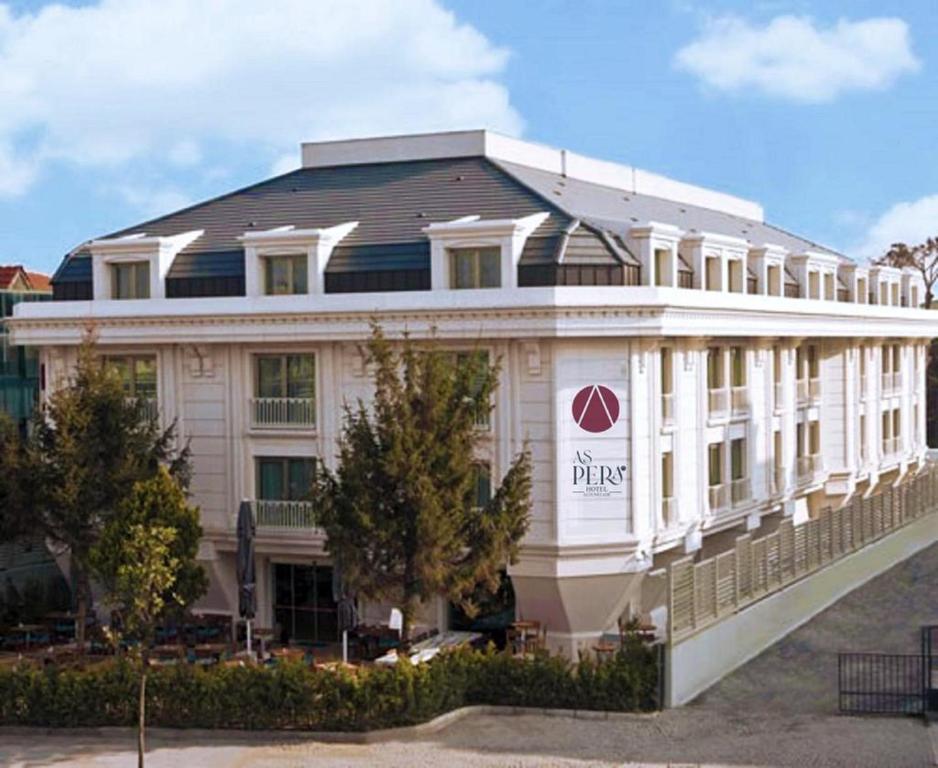 伊斯坦布尔Aspera Hotel Altunizade的一座白色的大建筑,上面有标志