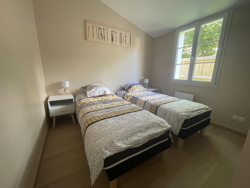 Les Sables VignierMaison neuve au calme idéale pour 4 voyageurs的带窗户的客房内设有两张单人床。